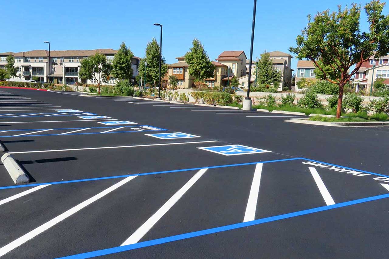 Freshly paved and striped asphalt parking lot with ADA-compliant parking spaces